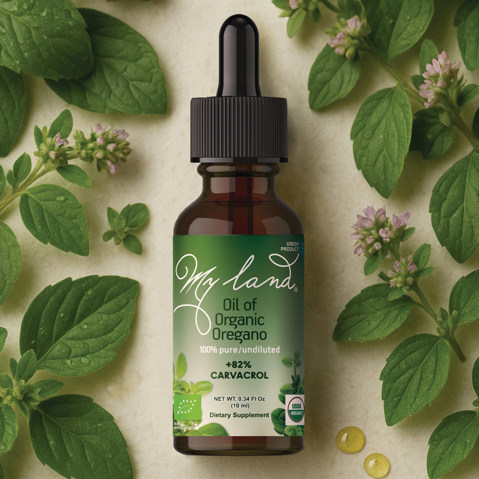 My Land oil of organic Greek oregano dropper bottle at 82% carvacrol, surrounded by fresh oregano leaves and flowers