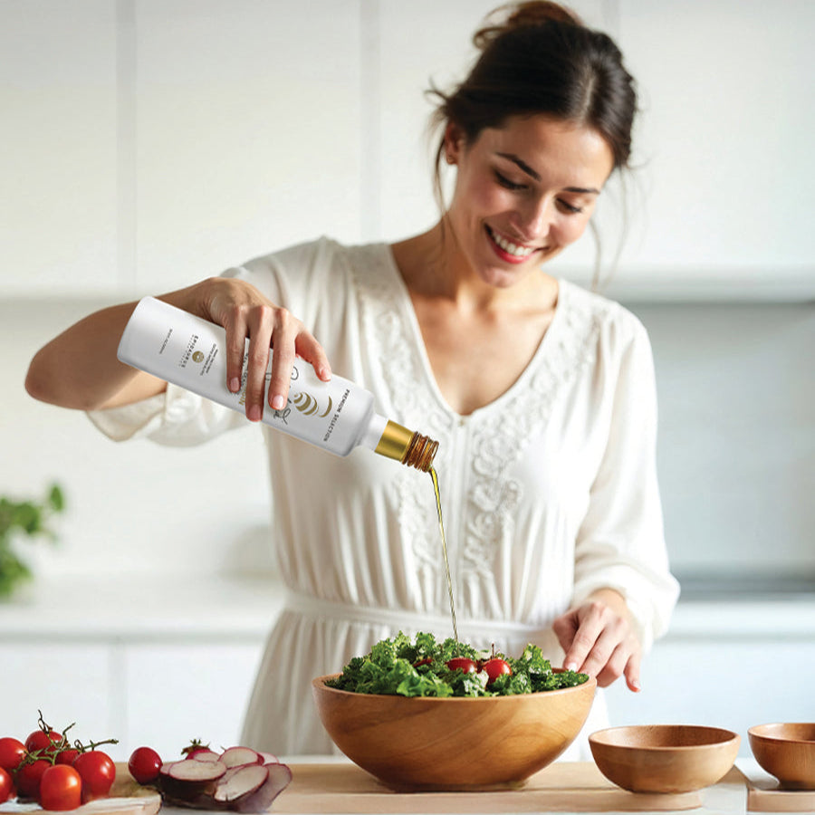 a woman using My Land olive oil in salad
