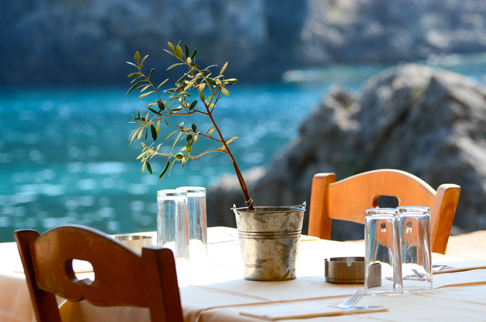My Land Brand, a simple Greek table next to the sea with a small olive three